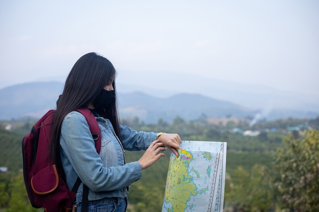 Free photo asian woman tourist wearing face mask looking at wrist watch