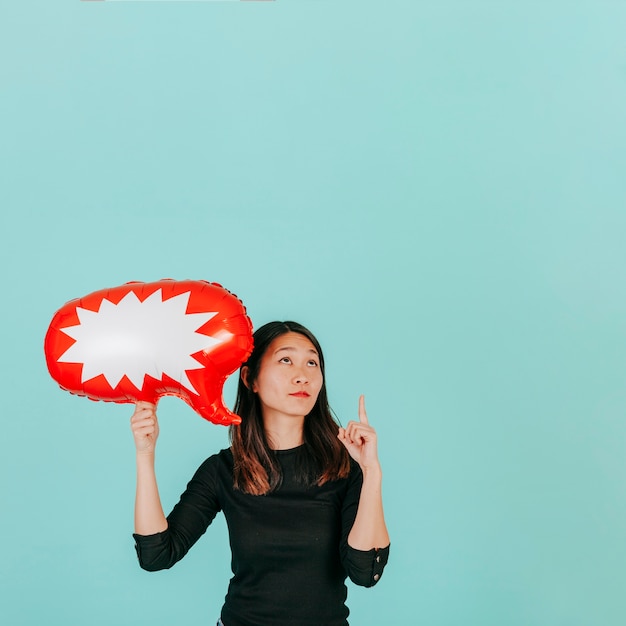 Free photo asian woman with speech balloon pointing up