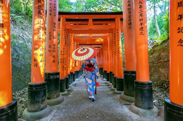 Free photo asian women in traditional japanese kimonos at fushimi inari shrine in kyoto, japan.