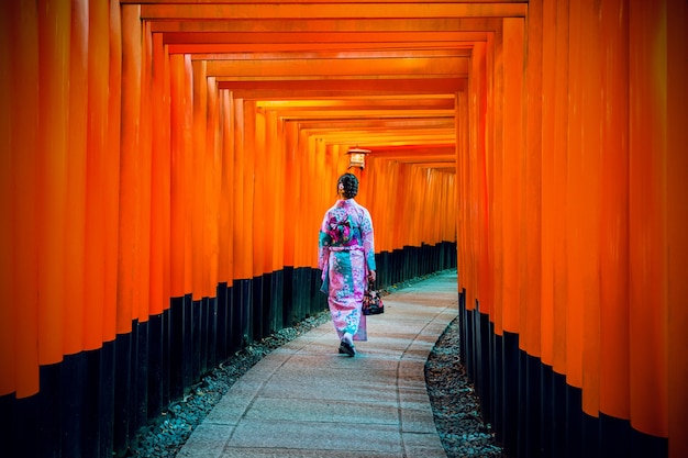 Free photo asian women in traditional japanese kimonos at fushimi inari shrine in kyoto, japan.