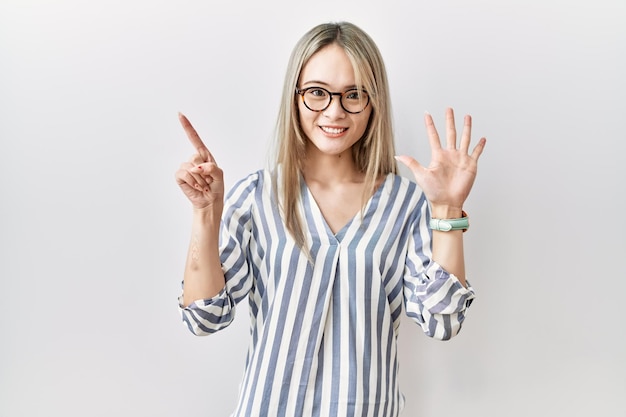 Free photo asian young woman wearing casual clothes and glasses showing and pointing up with fingers number six while smiling confident and happy.