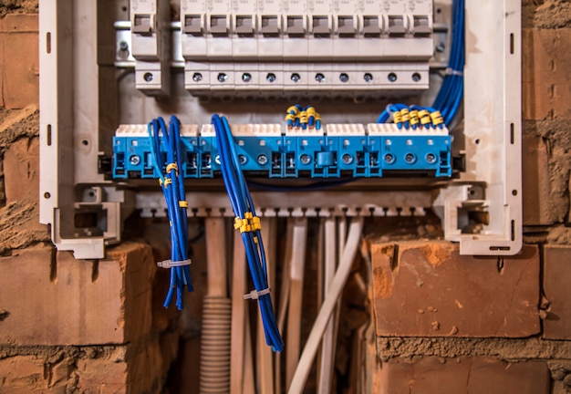 the Assembly of the electrical panel, electrician job, a robot with wires and circuit breakers