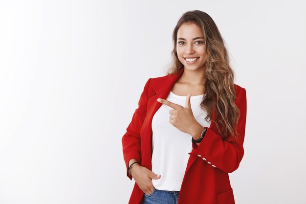 Assertive good-looking female entrepreneur standing confident pose hand pocket pointing index finger aside showing copy space self-assured, skillfull businesswoman offering intersting promo