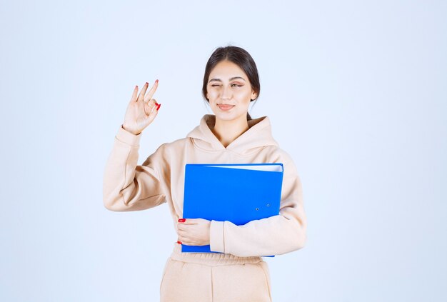 Assistant with a blue folder showing enjoyment sign