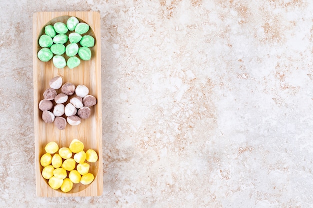 Free photo assorted candies bundled in a small wooden tray