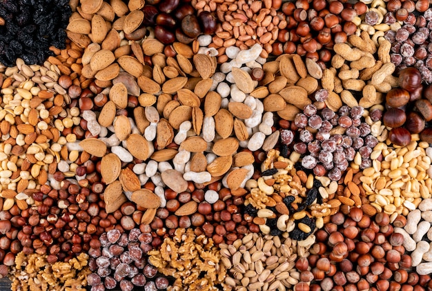 Assorted nuts and dried fruits with pecan, pistachios, almond, peanut, cashew, pine nuts top view