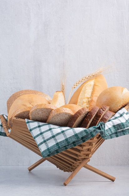 Assortment of bread in basket on marble surface