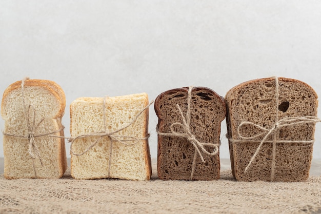 Assortment of bread tied with rope on burlap. High quality photo