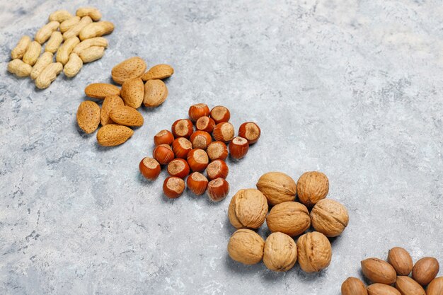 Assortment of nuts on concrete surface.Hazelnuts, walnuts, pecans, peanut,almonds,top view