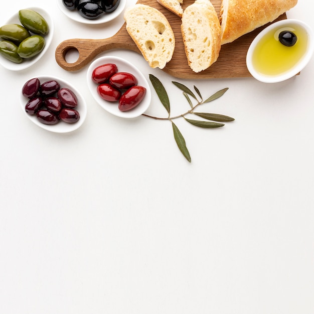 Free photo assortment of olives bread slices and olive oil with copy space