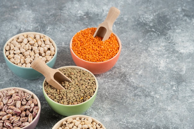 Assortment of raw dry legumes composition on marble table surface.