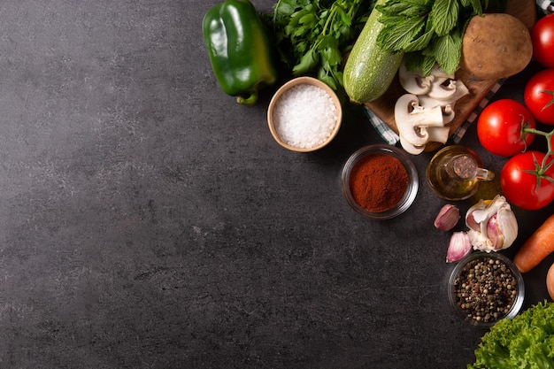 Free photo assortment of vegetables herbs and spices on black background top view copy space