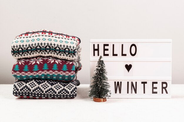 Free photo assortment with sweaters and hello winter sign