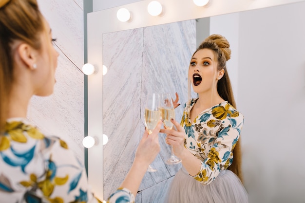 Free Photo astonished happy young woman with stylish coiffure in mirror in hairdresser salon