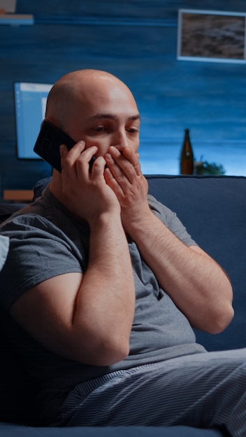 Free photo astonished man talking at phone receving horrible news