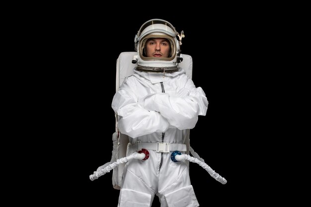 Astronaut day spaceman in cosmos space suit helmet hands crossed standing still in galaxy