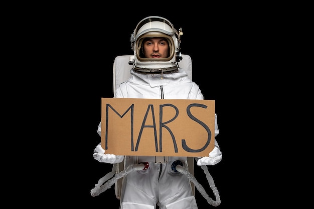 Free Photo astronaut day spaceman in galaxy space suit helmet holding mars written on cupboard