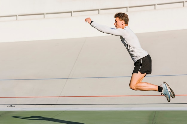 Athlete doing a long jump with copy space