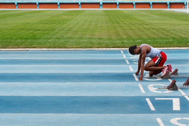 Free photo athlete on the starting line at the stadium