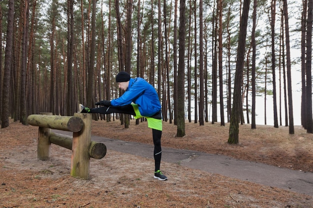 Free Photo athlete stretching leg in forest