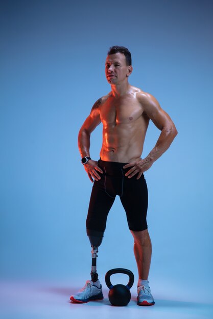 Athlete with disabilities or amputee isolated on blue studio