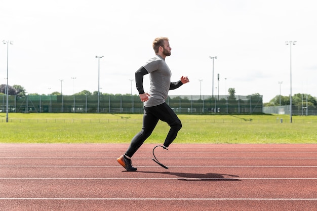 Free photo athlete with prosthesis running full shot