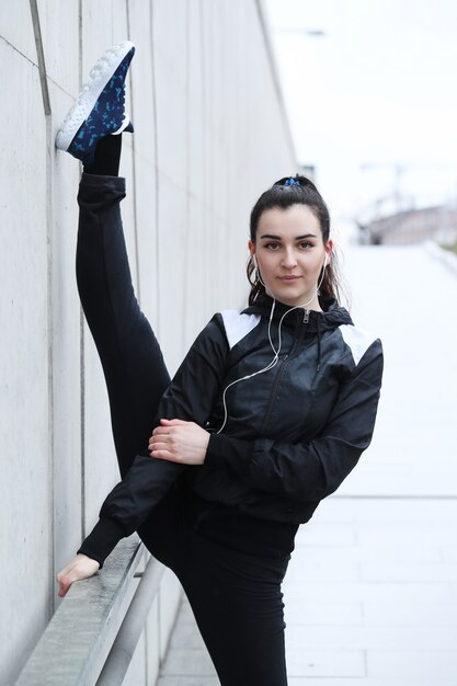 Athlete woman doing stretching in the street