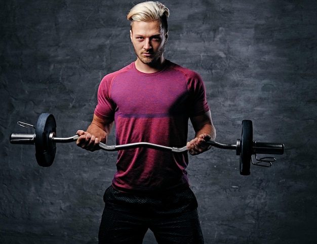 Free photo athletic blond male doing a biceps workout with a barbell.