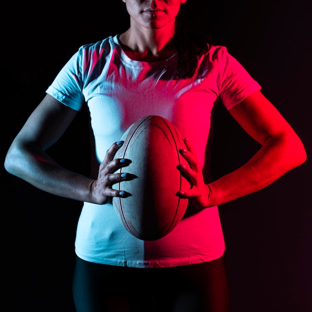 Athletic female rugby player holding ball