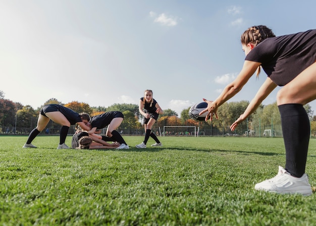 Athletic girl trying to catch a rugby ball