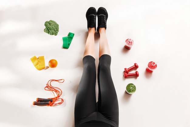 Free Photo athletic girl with healthy food on floor