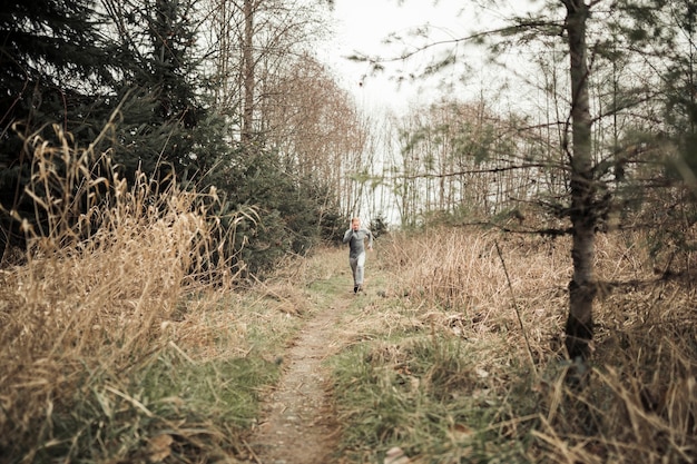 Free photo athletic male running on forest trail