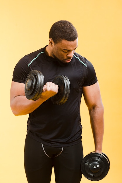 Athletic man holding weights in gym outfit