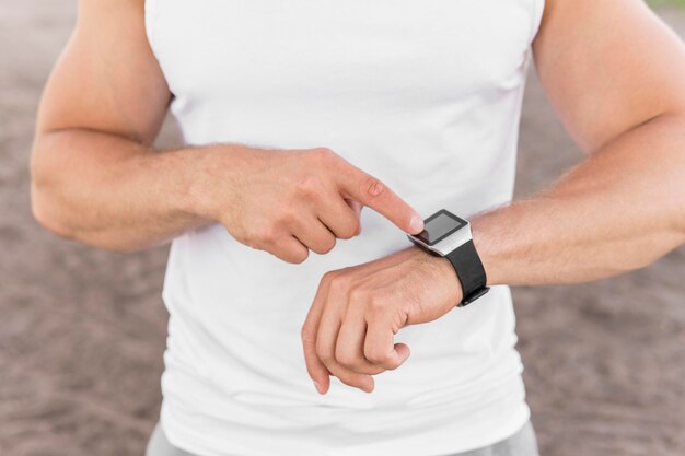 Athletic man pointing to his smartwatch