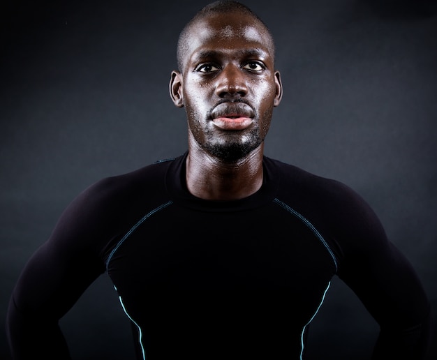 Athletic man running in black background.