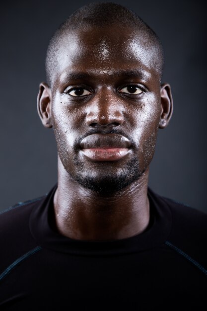 Athletic man running in black background.