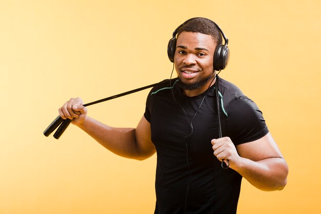 Athletic man with headphones and jumping rope