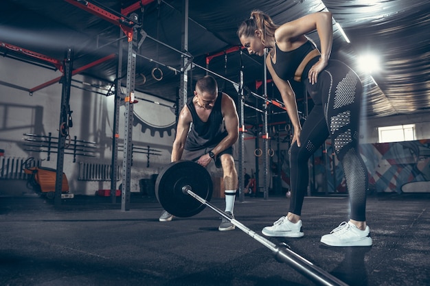 Athletic man and woman with dumbbells