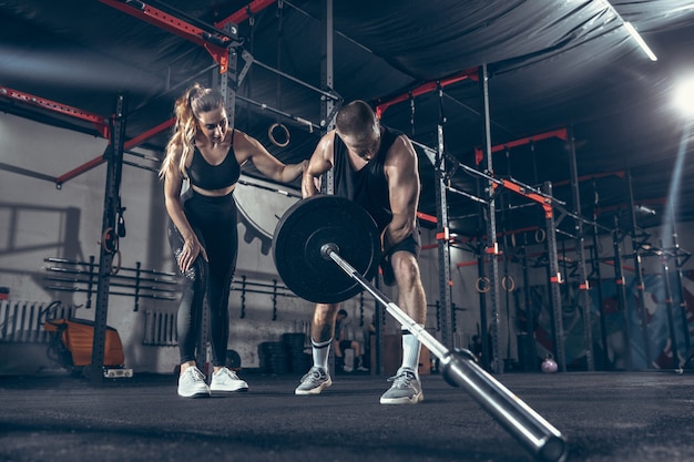 Athletic man and woman with dumbbells