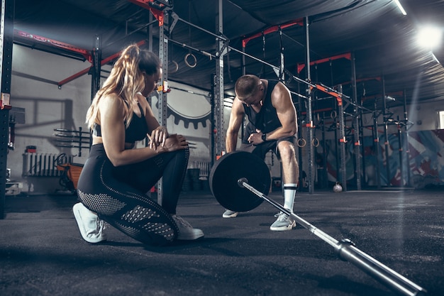 Athletic man and woman with dumbbells