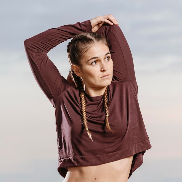 Free photo athletic woman by the beach posing while stretching