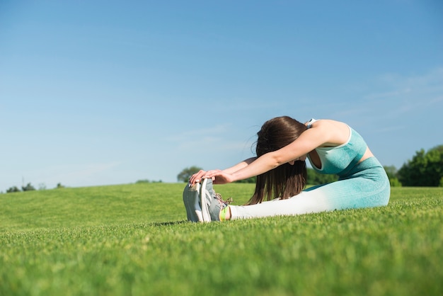 Free photo athletic woman practicing yoga outdoor