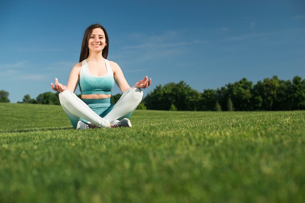 Free photo athletic woman practicing yoga outdoor