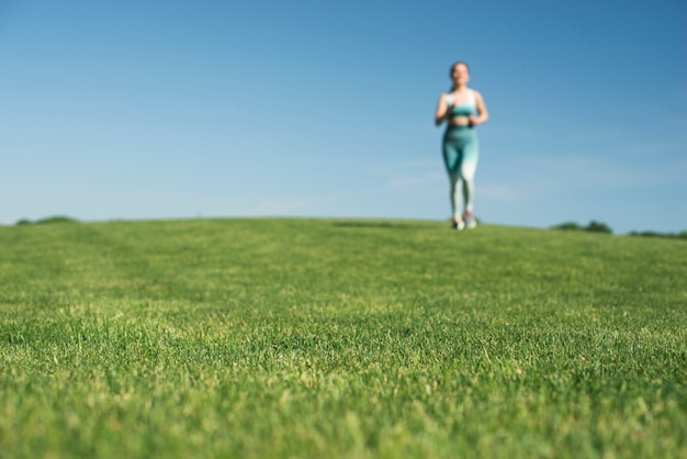 Athletic woman running outdoor in a park