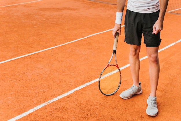 Athletic young tennis player posing