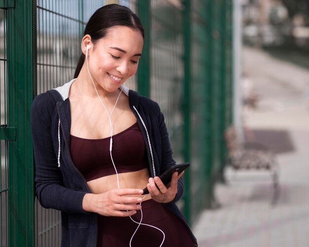 Athletic young woman browsing mobile phone