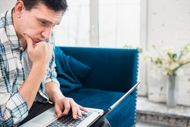 Attentive man staring at laptop at home