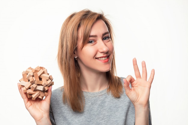 Free photo attractive 24 year old business woman looking confused with wooden puzzle.