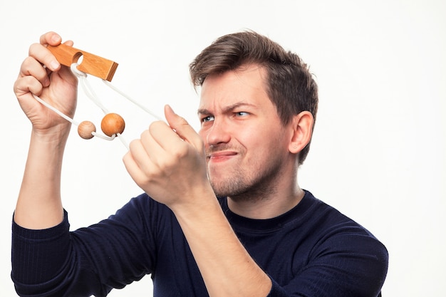 Attractive 25 year old business man looking confused at wooden puzzle.