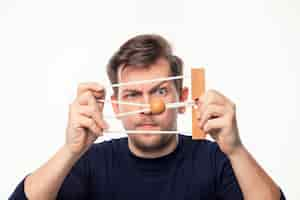 Free photo attractive 25 year old business man looking confused at wooden puzzle.